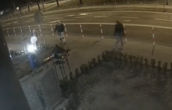Kadr nagrania zarejestrowanego przez monitoring miejski. Na zdjęciu widoczne trzy osoby. Jedna z nich celowo niszczy lampy znajdujące się przed Biblioteką Miejską w Wolsztynie.