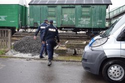 Policjanci Wydziału Prewencji kierują się w stronę wagonu stojącego na bocznicy kolejowej przy dworcu PKP w Wolsztynie, gdzie według zgłoszenia doszło do włamania.