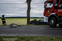 Miejsce śmiertelnego potrącenia. Na pierwszym planie wóz strażacki, w oddali rozbity samochód, rower i drzewo.