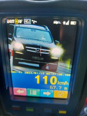 Widok ekranu urządzenia pomiarowego, za pomocą którego zarejestrowana została prędkość kierowcy. Sylwetka samochodu marki Mercedes koloru czarnego, poniżej wskazanie 110 km/h.