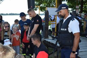 Akcja profilaktyczna &quot;Kręci mnie bezpieczeństwo nad wodą&quot; nad jeziorem Wieleńskim. Policjant - motorowodniak przypatrujący się pokazowi udzielania pierwszej pomocy.