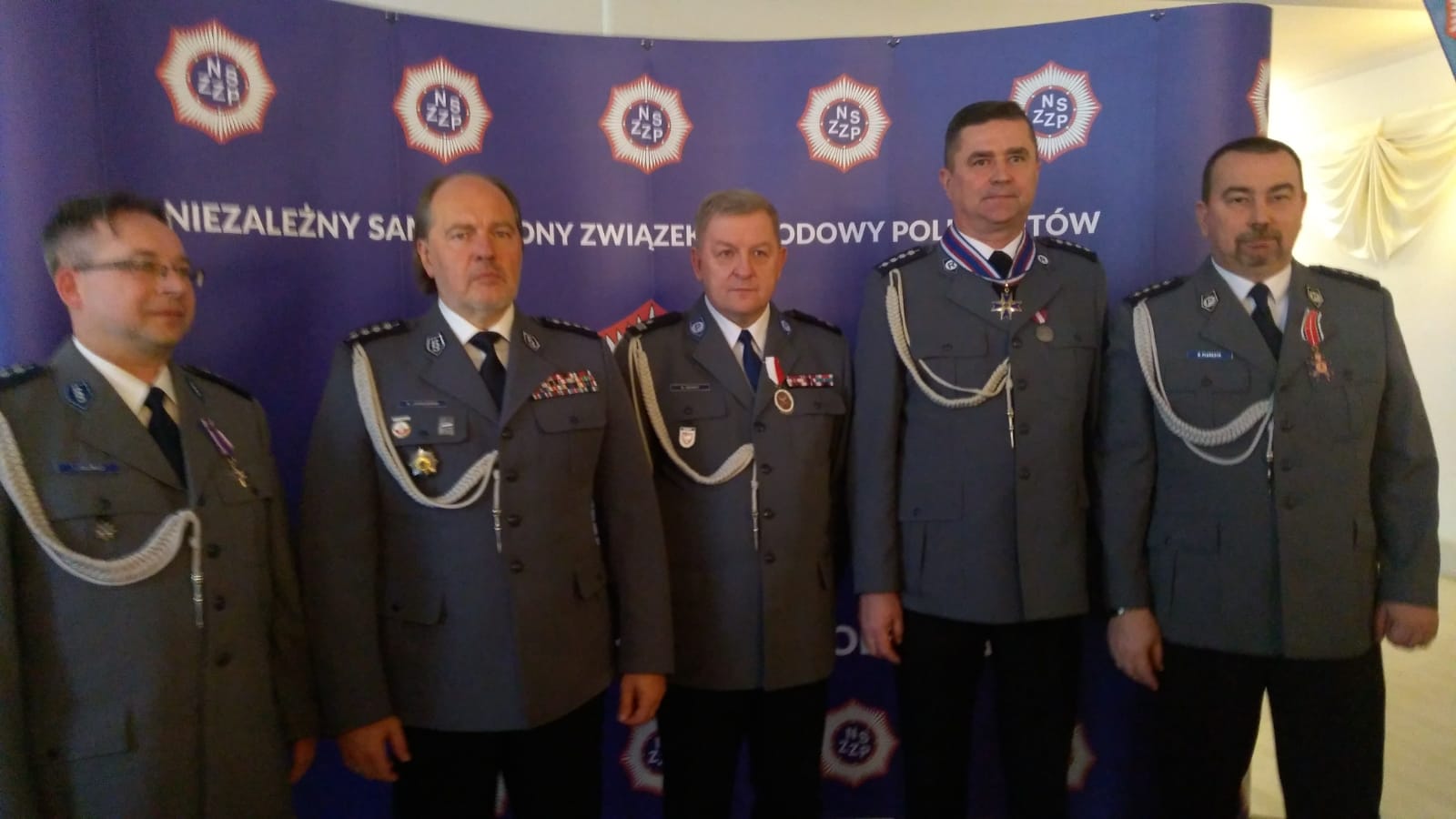 Ustawieni w szeregu policjanci odznaczeni medalami związkowymi. Wsród nich dwaj policjanci w KPP w Wolsztynie - Piotr Horowski i Robert Pluskota. 