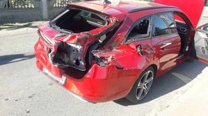 Zbliżenie na uszkodzony samochód Seat Leon kombi koloru czerwonego. Zniszczony w następstwie zderzenia tył samochodu.
