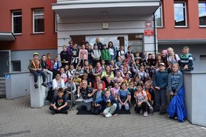 Dzieci - uczniowie Szkoły Podstawowej w Kaszczorze podczas wizyty w Komendzie Powiatowej Policji w Wolsztynie. Grupowe zdjęcia na schodach do wejścia głównego.