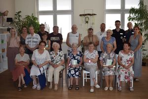 Pomieszczenie Domu Dziennego Pobytu Senior+ w Wolsztynie. Zdjęcie grupowe uczestników spotkania.
