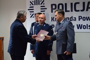 Uroczysta zbiórka w sali konferencyjnej Komendy Powiatowej Policji w Wolsztynie. Komendant odbiera gratulacje od Starosty Wolsztyńskiego.