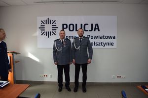 Uroczystość pożegnania przechodzącego na emeryturę komisarza Rafała Płóciniczaka. Przewodniczący ZT NSZZ Policjantów w Wolsztynie pozuje do zdjęcia z odznaczonym policjantem-emerytem.