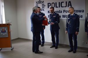 Starosta Wolsztyński wręcza upominki nowo powołanemu Komendantowi Powiatowemu Policji w Wolsztynie.