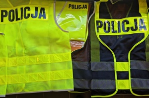 Zbliżenie na kamizelki odblaskowe w kolorze żółtym z czarnym napisem POLICJA