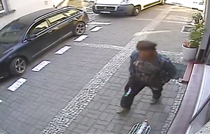 Zarejestrowany przez kamerę monitoringu sprawca kradzieży roweru. Mężczyzna w średnim wieku idzie w kierunku roweru, który w konsekwencji kradnie.