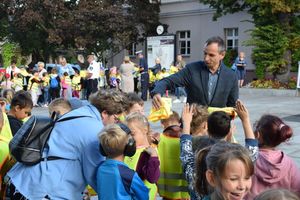 Akcja ODBLASKOWY MALUCH zorganizowana na wolsztyńskim Rynku. Organizatorzy akcji, tu Zastępca Burmistrza Wolsztyna, rozdają kamizelki dzieciom.