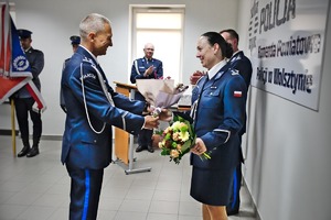 Zastępca Komendanta Powiatowego Policji w Wolsztynie wita nową Komendant wręczając kwiaty.