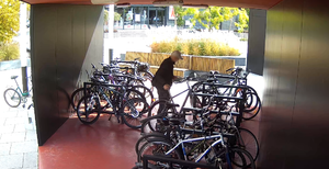 Kadr nagrania monitoringu miejskiego, na którym widoczny jest mężczyzna kradnący rower. Spośród kilkudziesięciu jednośladów mężczyzna wybiera jeden i wyprowadza go z rowerowni przy dworcu PKP.