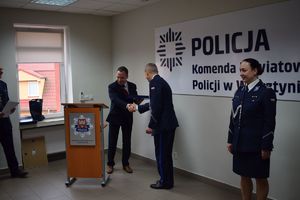 Sala Konferencyjna KPP w Wolsztynie. Burmistrz Wolsztyna wręcza I Zastepcy Komendanta Powiatowego Policji w Wolsztynie okolicznościowy ryngraf.