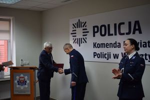 Sala Konferencyjna KPP w Wolsztynie. Wójt Gminy Siedlec składa gratulacje I Zastepcy Komendanta Powiatowego Policji w Wolsztynie.