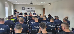 Policjanci podczas narady służbowej przed zabezpieczeniem uroczystości pogrzebowych