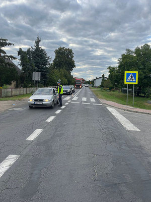 Umundurowany policjant ruchu drogowego kontroluje trzeźwość kierujących podczas akcji TRZWEŹWY PORANEK