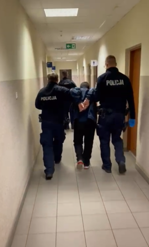 Policjanci prowadzą zatrzymanego