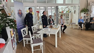 Debata społeczna w Domu Dziennym Senior+. Stojąca za stołem prezydialnym Komendant Powiatowy Policji w Wolsztynie w asyście Zastępcy Naczelnika Wydziału Prewencji dziękuje wszystkim za udział w debacie.