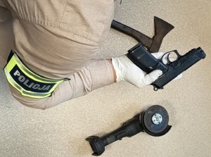 Policjant w rękawiczce prezentuje broń gazową