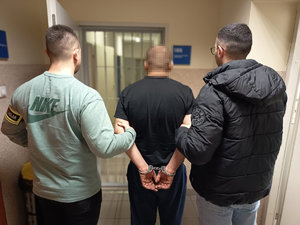 Policjanci prowadzą zatrzymanego